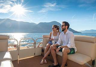Una coppia che si gode una gita in barca con champagne sul Lago Maggiore al Sunstar Hotel Brissago