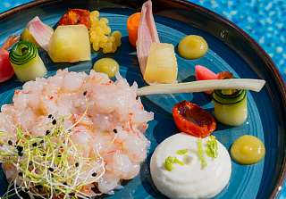 Garnelen Tatar auf Teller mit blauem Hintergrund